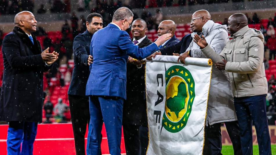 CAF President Patrice Motsepe with African football officials holding a CAF flag