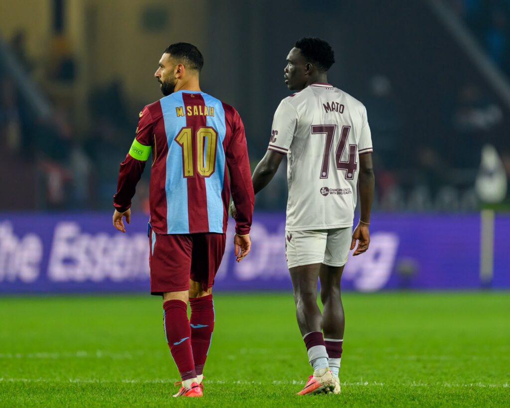 Uganda Cranes star Rogers Mato walks alongside Mohamed Salah following Hearts' encounter with Trabzonspor, where Mato played at left-back.
