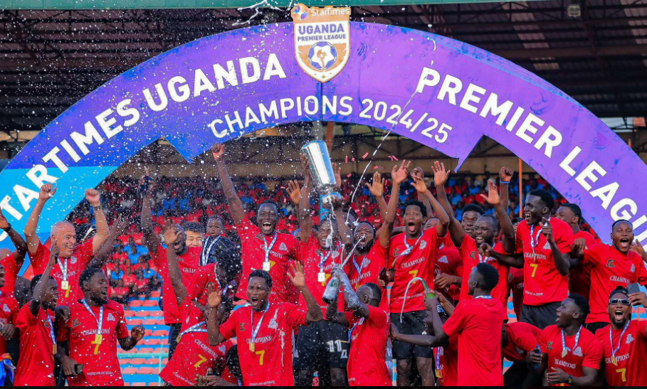Vipers SC players lift the trophy beneath the 2024/25 Uganda Premier League champions banner during their title celebrations.