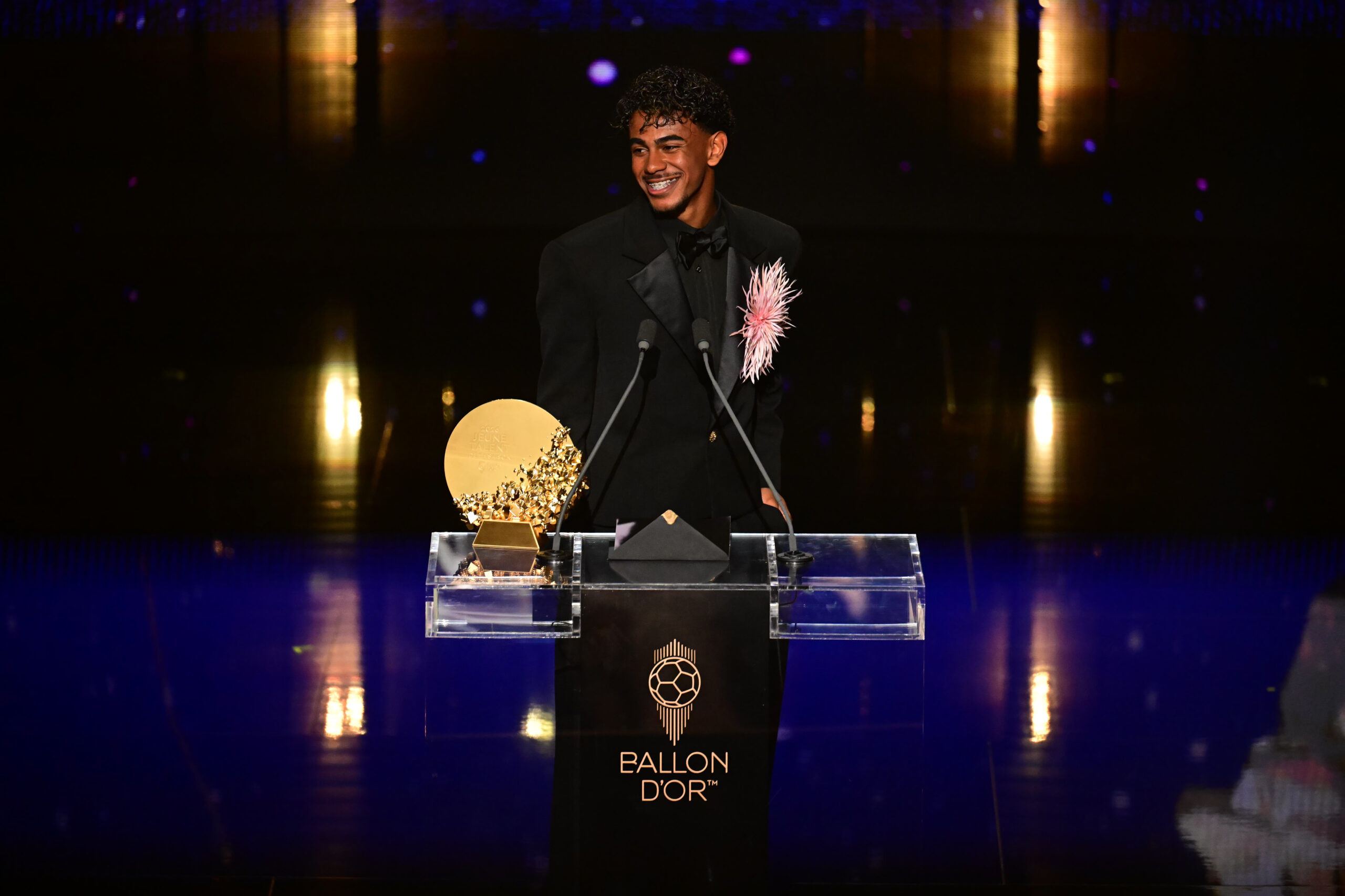 Lamine Yamal smiles at the podium beside his Young Talent trophy during the 2026 Ballon d’Or ceremony.